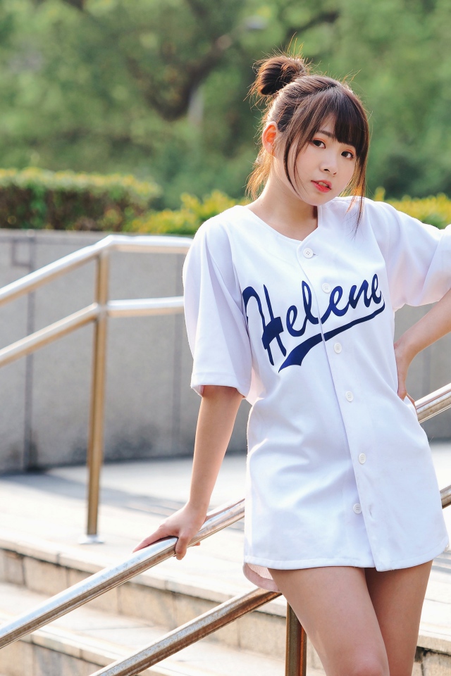 Симпатичная молодая азиатка стоит у перил