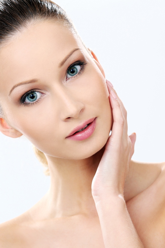 Нежная голубоглазая девушка без макияжа на белом фоне