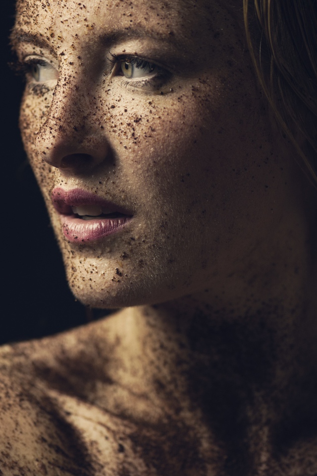 Грязная девушка в земле на черном фоне