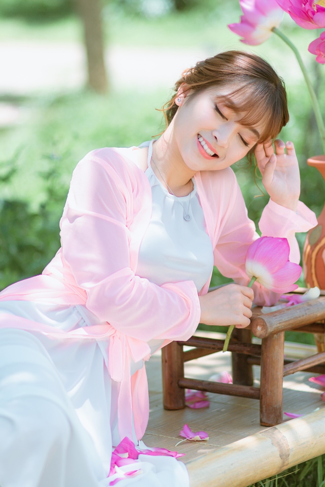 Мечтательная девушка азиатка с цветами лотоса