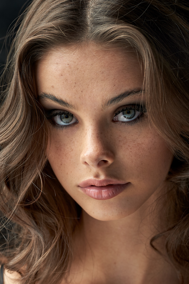 Лицо красивой девушки с веснушками на лице 