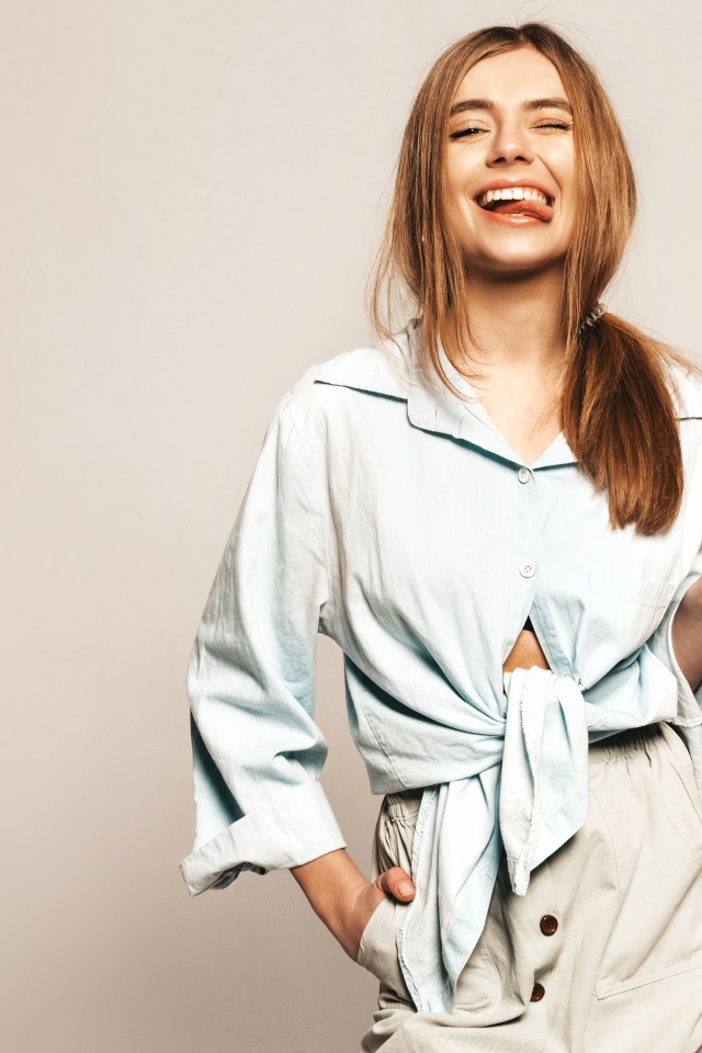 Смешная девушка в рубашке с высунутым языком