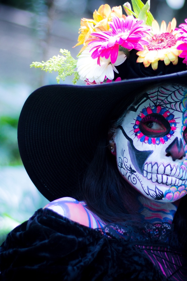 Девушка с маской на лице в черной шляпе