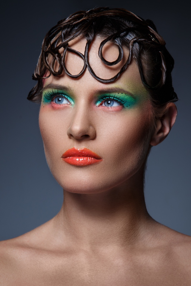 Девушка с ярким макияжем на сером фоне 