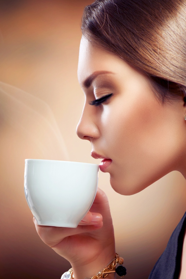 Девушка с закрытыми глазами наслаждается кофе