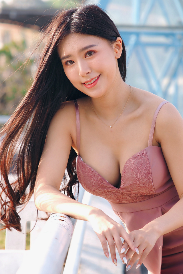 Длинноволосая брюнетка азиатка в розовом платье 