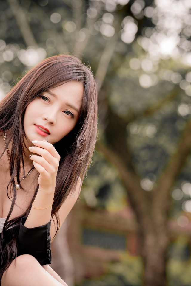 Задумчивая девушка азиатка в черном платье 