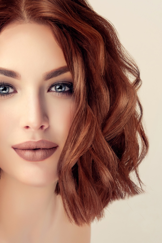 Рыжеволосая голубоглазая девушка на сером фоне