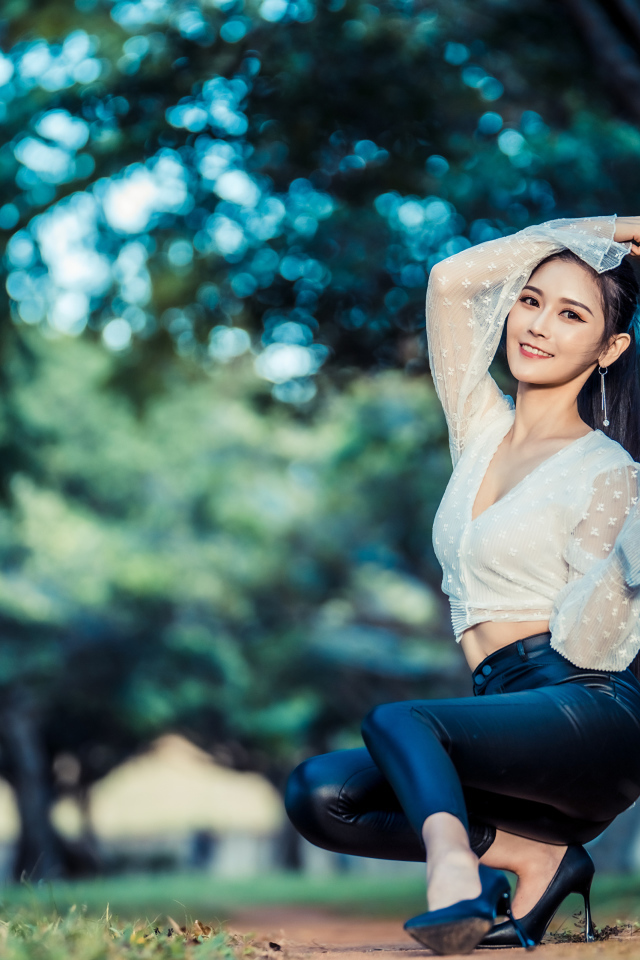 Улыбающаяся азиатка в черных брюках