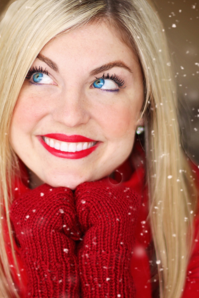 Улыбающаяся голубоглазая девушка в красном свитере 