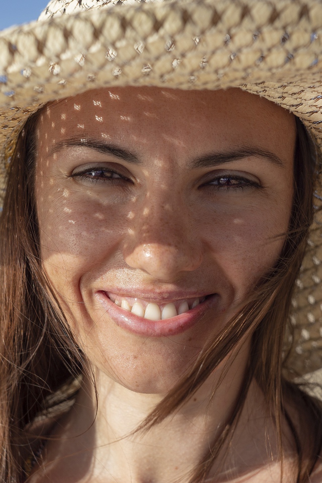 Smiling brown-eyed girl in a straw hat