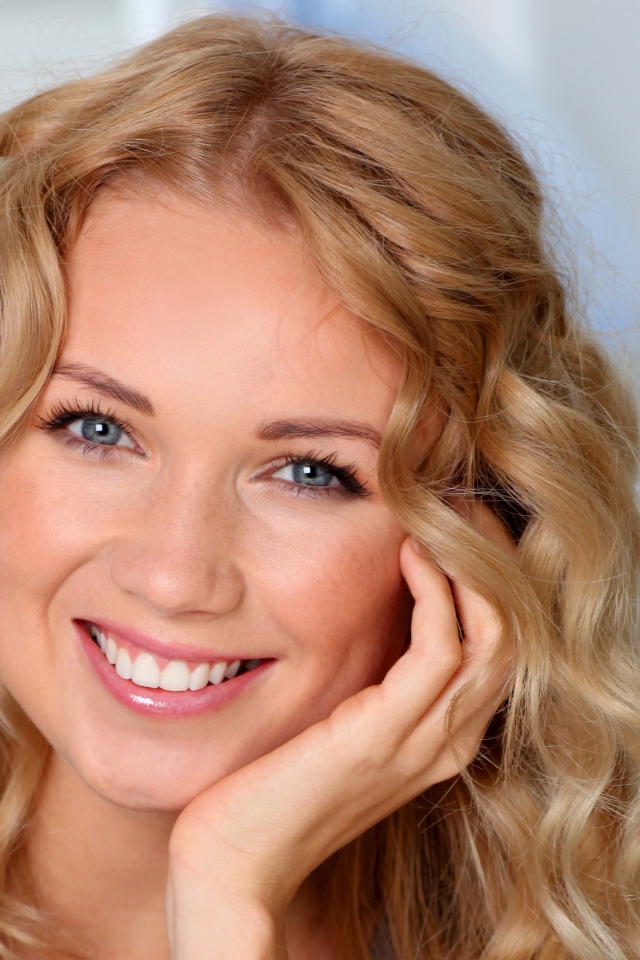 Улыбающаяся девушка в голубыми глазами 