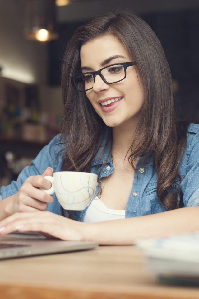 Улыбающаяся девушка в очках с ноутбуком