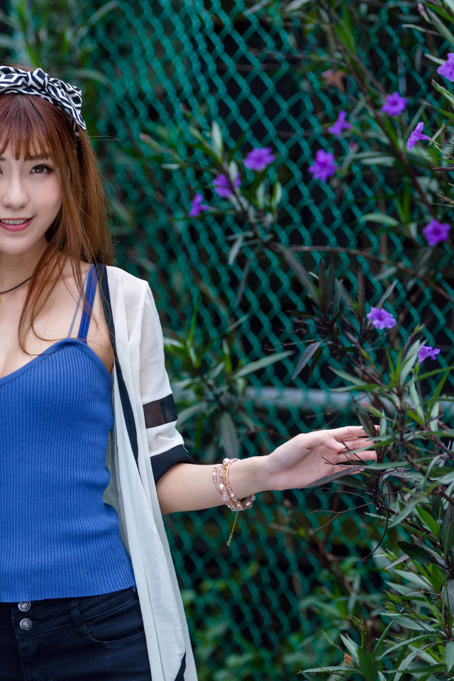 Улыбающаяся девушка фотограф стоит у сетки 