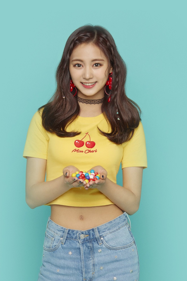 Улыбающаяся девушка с конфетами в ладонях на голубом фоне 