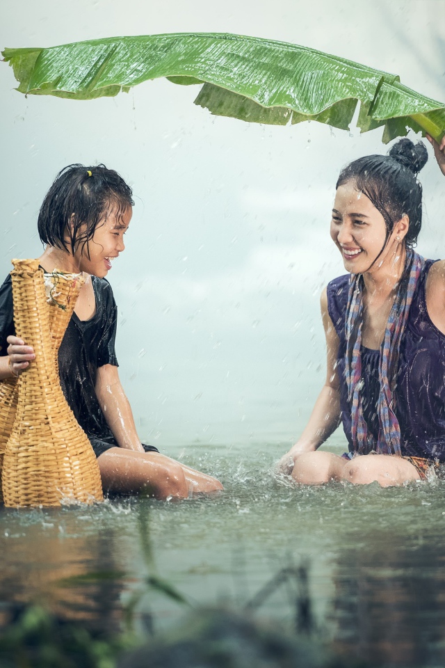Две девушки азиатки под дождем в воде