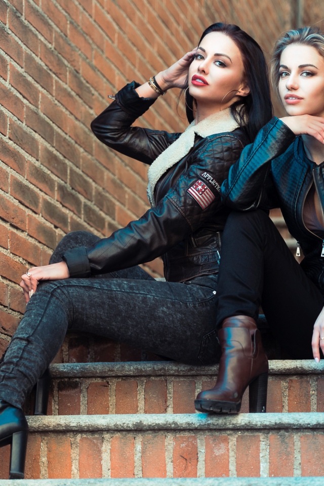 Две красивые девушки сидят на ступенях 