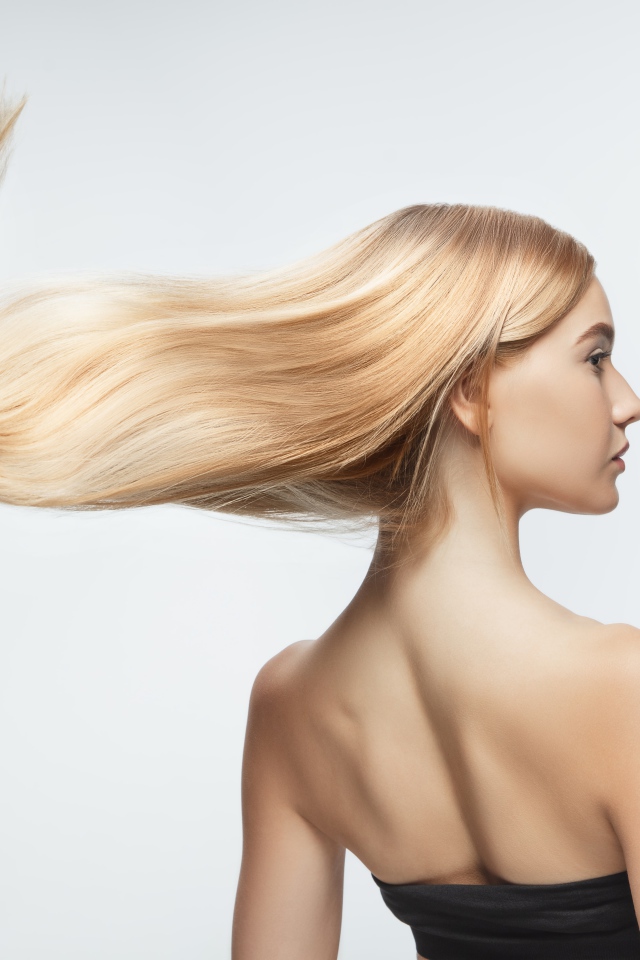 Белые волосы девушки развиваются на белом фоне 