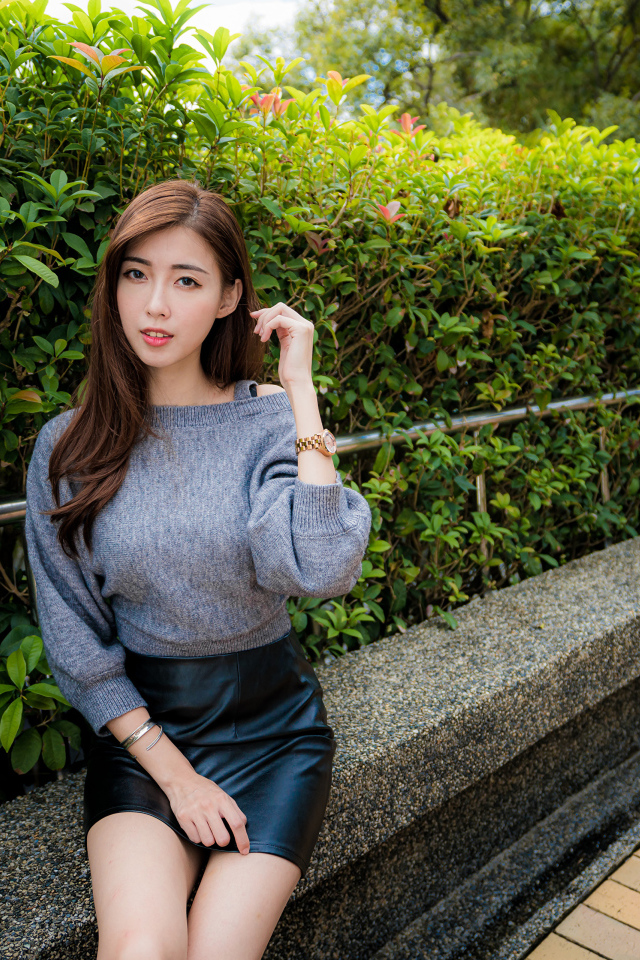 Молодая девушка азиатка в сером свитере 