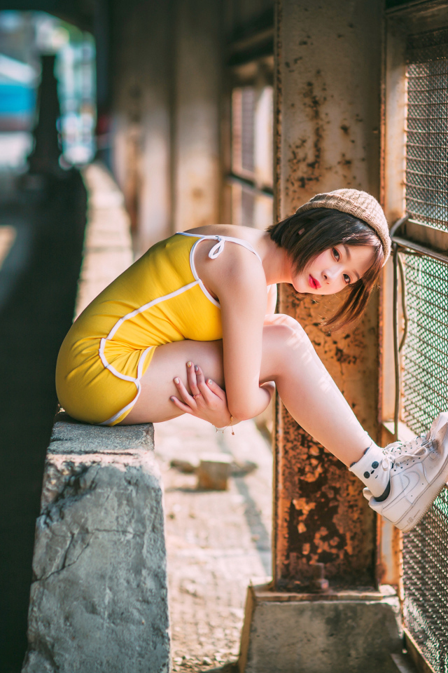 Молодая девушка азиатка сидит у сетки