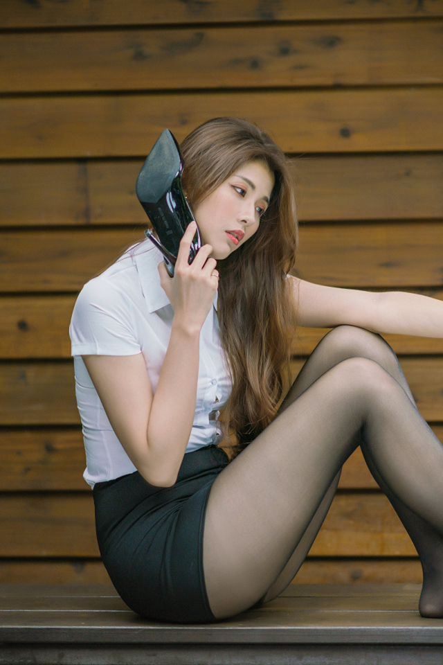 Молодая азиатка с черными туфлями в руках 