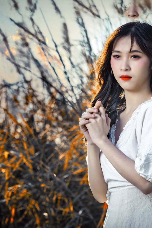 Молодая девушка азиатка в белом платье на закате