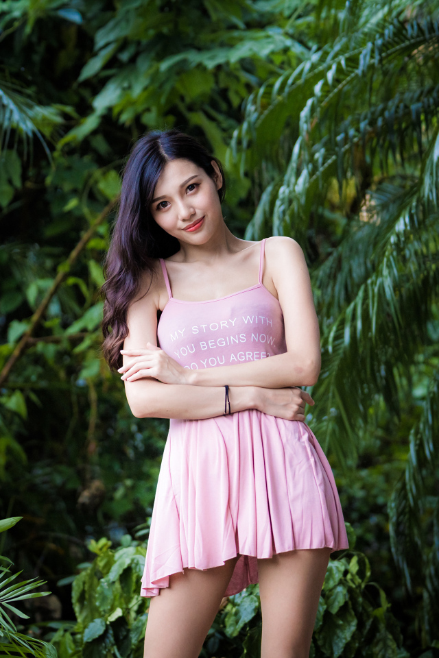 Молодая девушка азиатка на фоне зеленых листьев