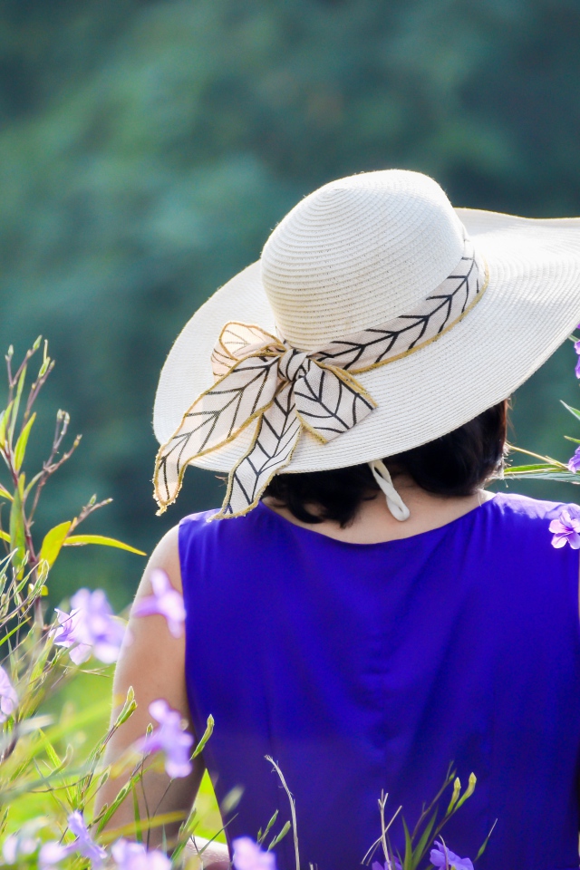 Молодая девушка в шляпе с букетом цветов 