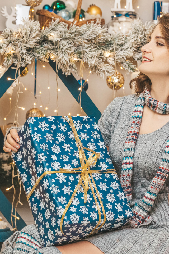 Красивая девушка с большим подарком на Рождество