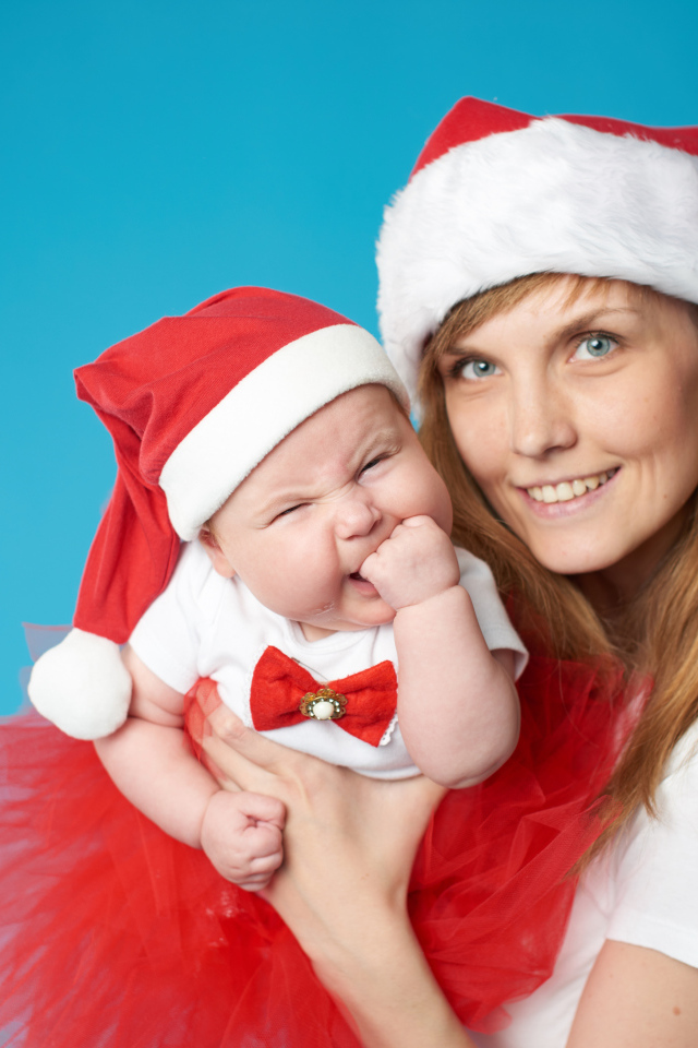 Девушка с ребенком в новогодних костюмах на голубом фоне