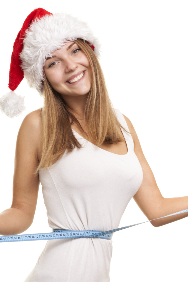 Стройная девушка в новогодней шапке на белом фоне