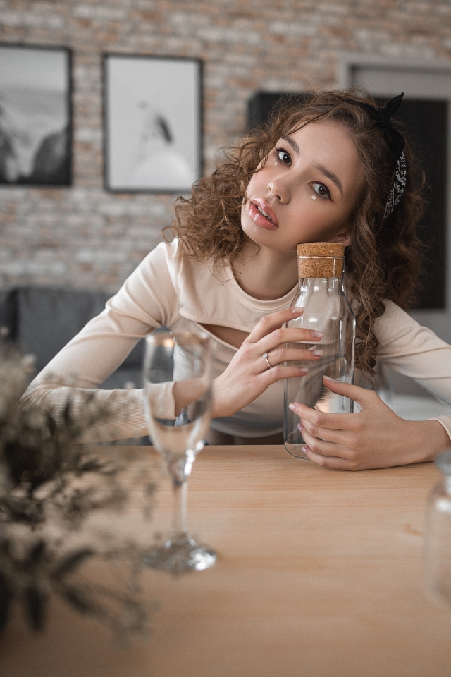 Young girl model sits in a cafe at the table