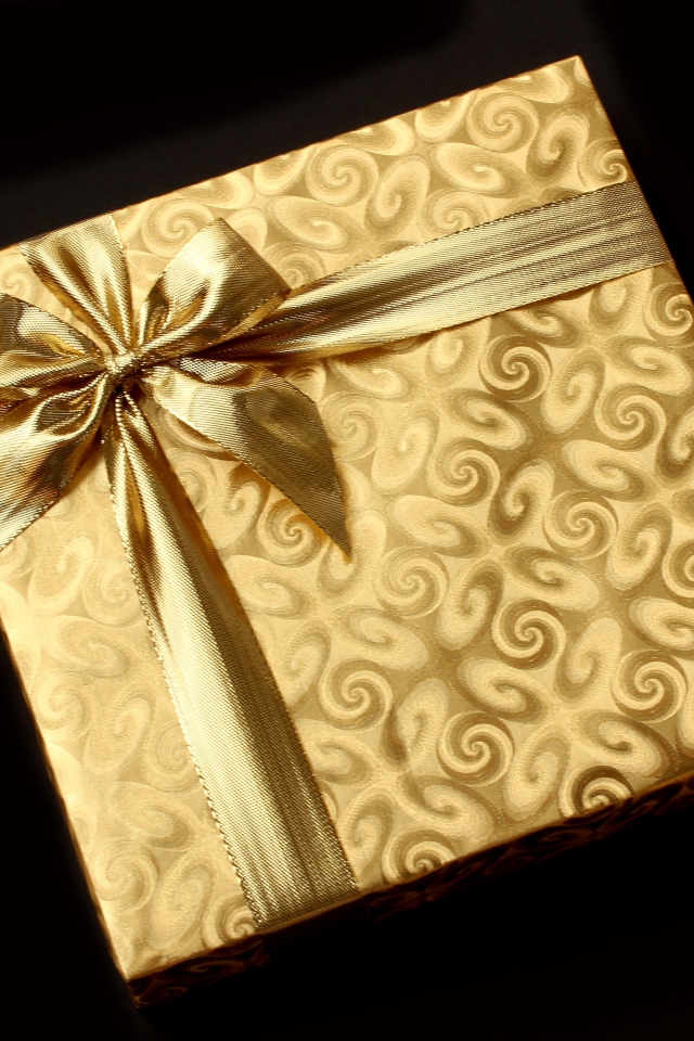 Золотая упаковка с подарком на черном фоне