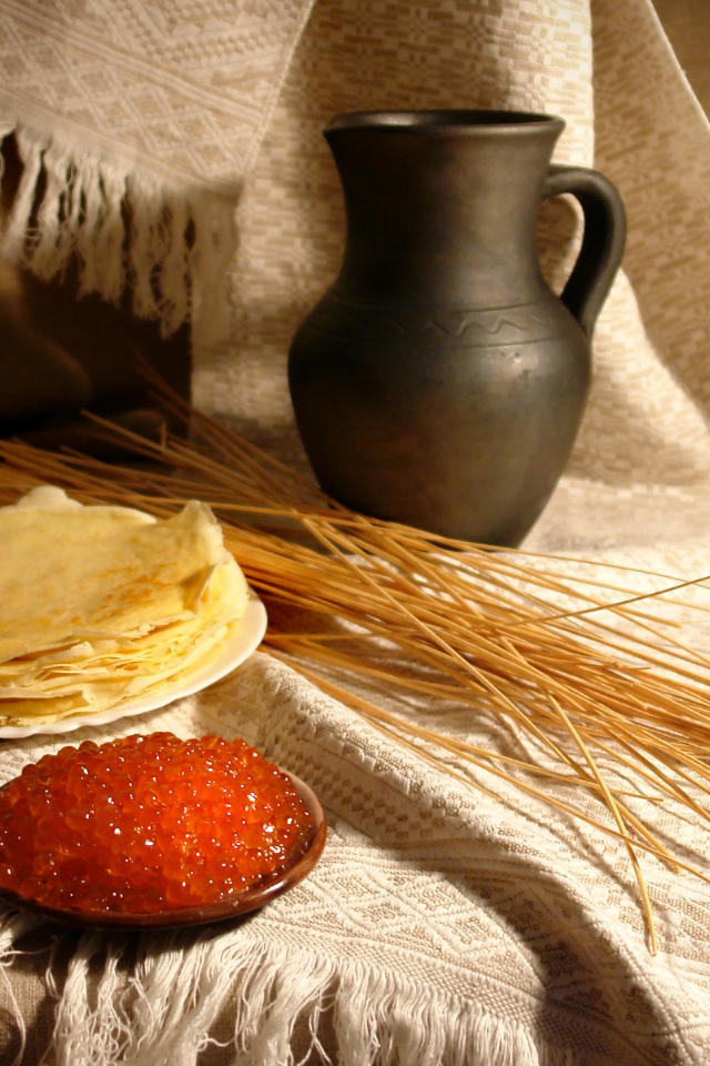 Блины с икрой на столе с колосьями на праздник Масленица