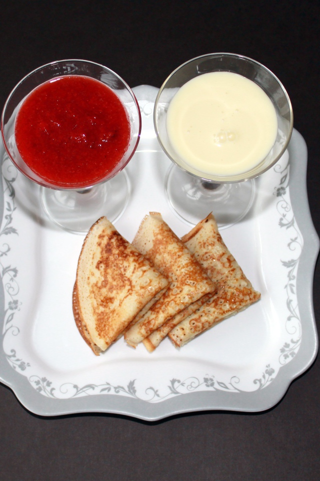 Блинчики с вареньем и сметаной на столе на Масленицу