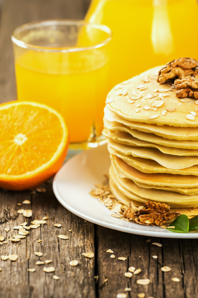 Блины с орехами на столе с апельсиновым соком на Масленицу