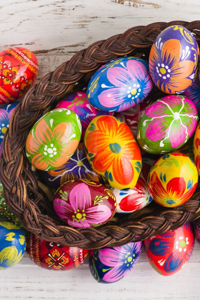 Красивые крашеные яйца в корзине на столе на праздник Великой Пасхи