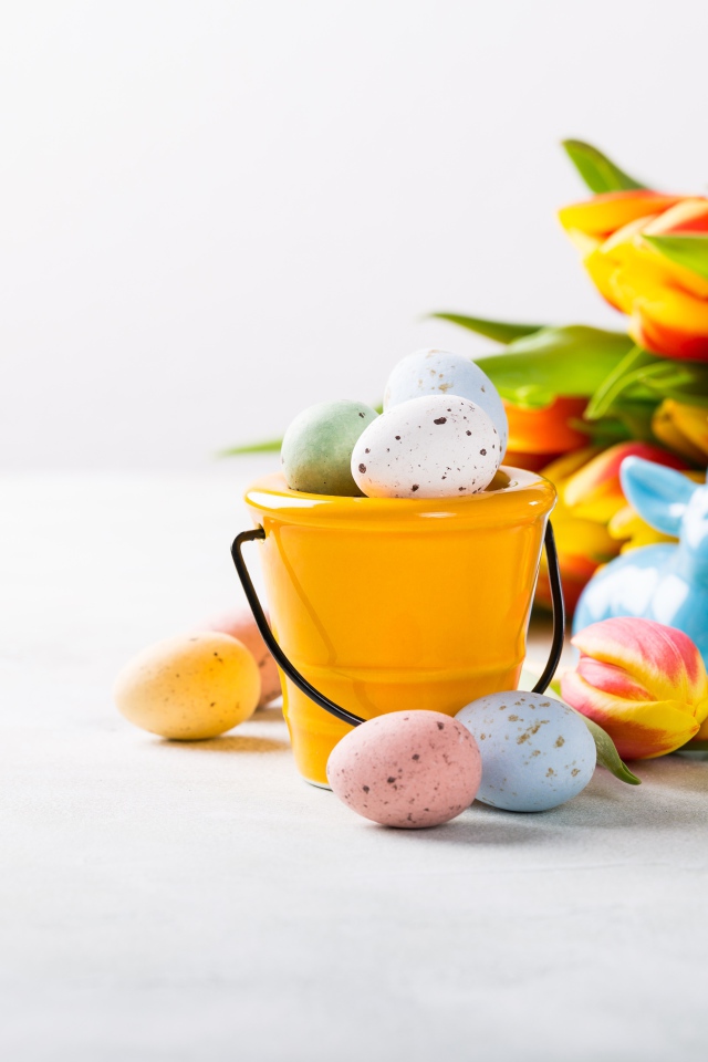 Букет тюльпанов на белом фоне с крашеными яйцами на Пасху