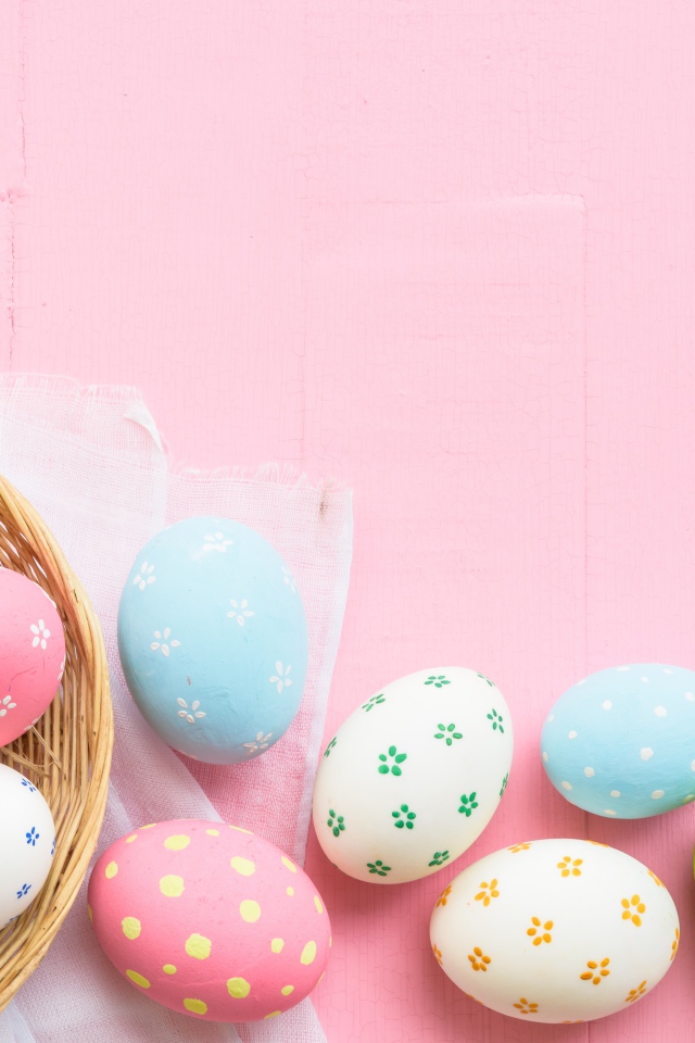 Разноцветные пасхальные яйца на розовом фоне