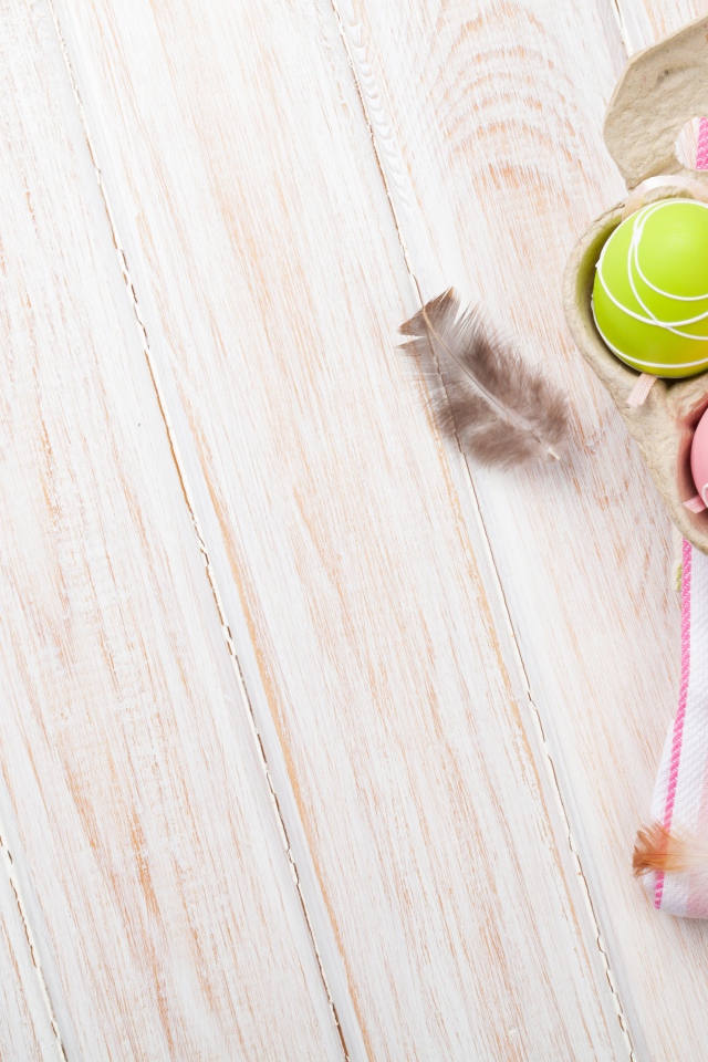 Крашеные пасхальные яйца на столе с тюльпанами