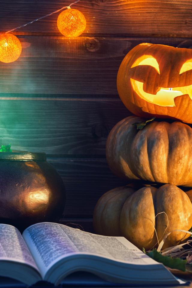Тыква, магическая книга и свечи на столе на Хэллоуин
