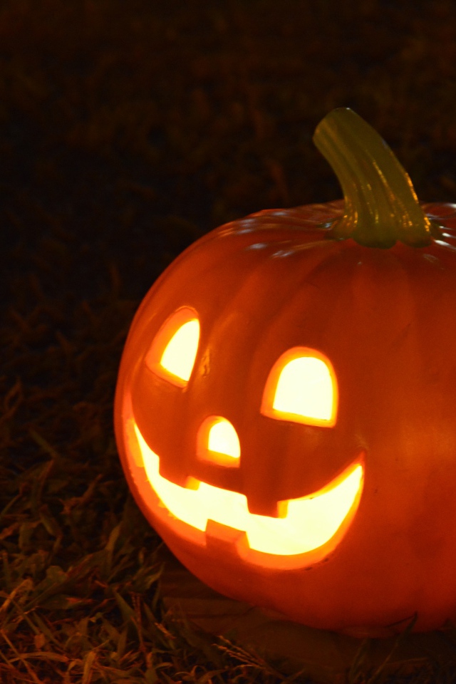 Светильник из тыквы на черном фоне на праздник Хэллоуин