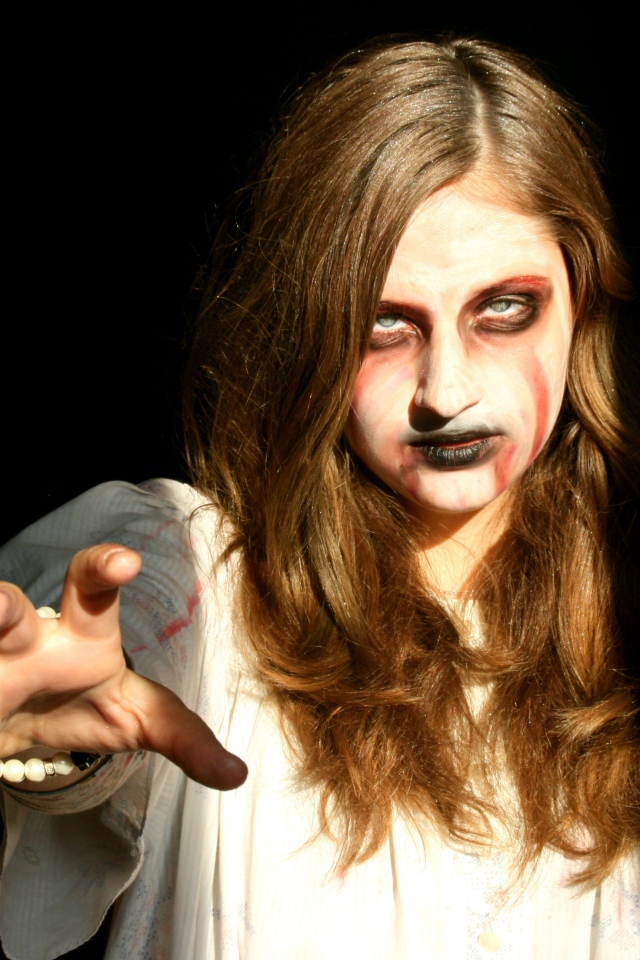 Девушка зомби на черном фоне в костюме на Хэллоуин