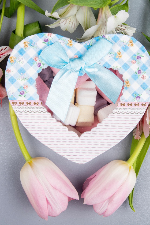 Коробка конфет в форме сердца и цветы на сером фоне на 8 марта