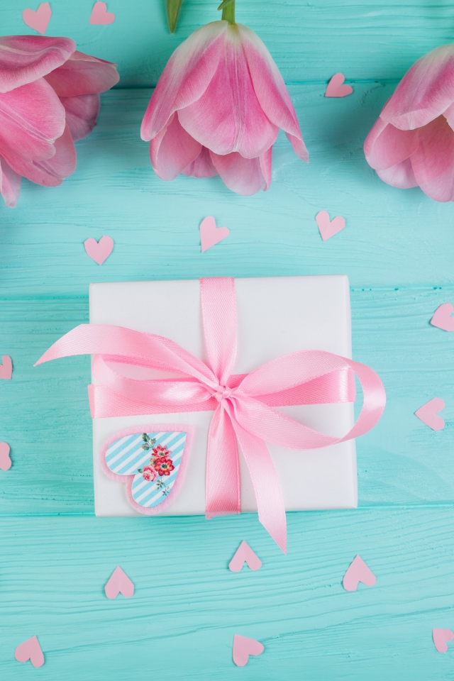 Розовые тюльпаны с подарком на голубом фоне на 8 марта