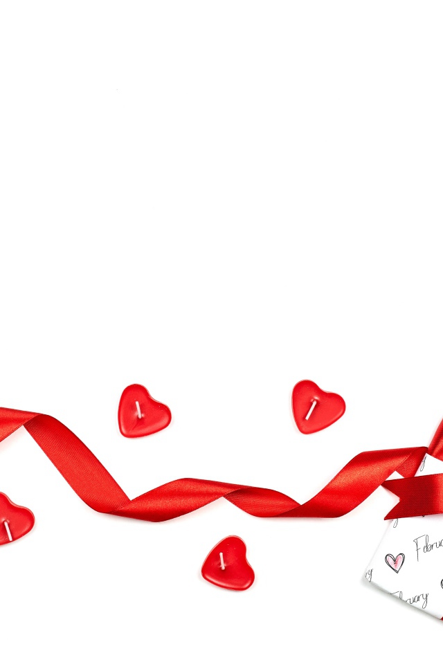 Подарок с красной лентой и свечами на белом фоне на День Святого Валентина