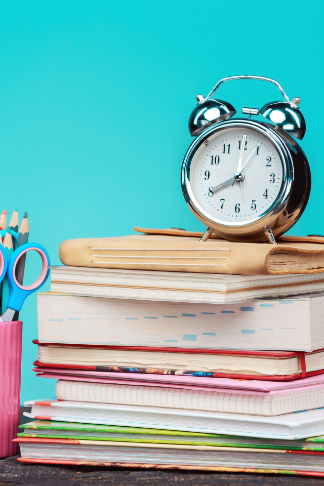 Будильник, книги и канцелярские предметы для школы