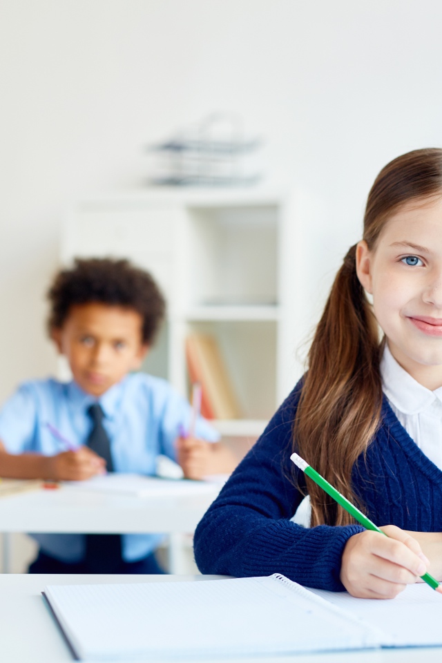 Девочка школьница сидит за партой в школе 