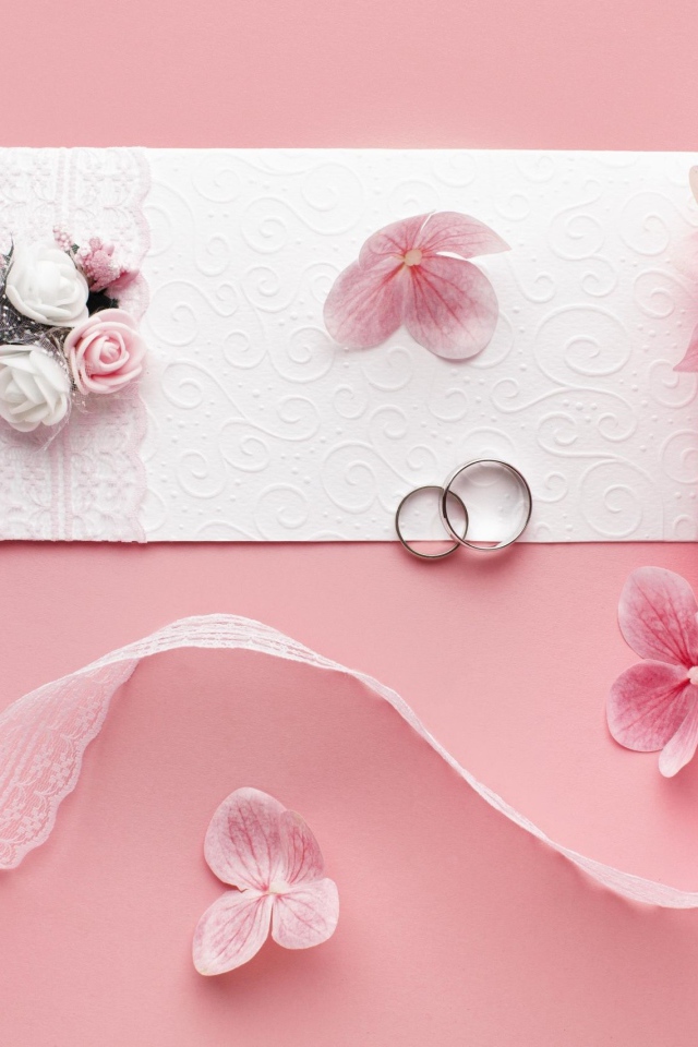 Белое приглашение на свадьбу с цветами на розовом фоне