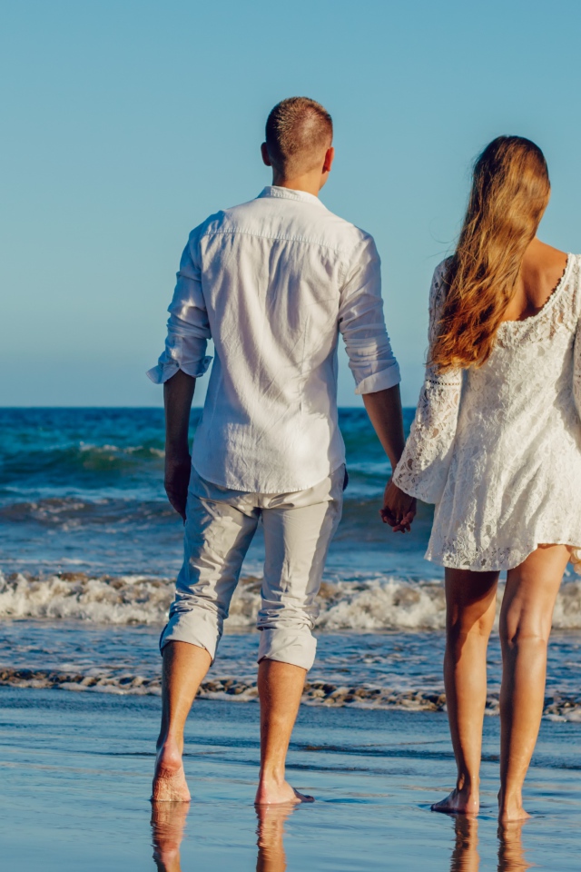 A loving couple walks along the seashore